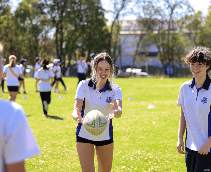 Students on the oval throwing a football